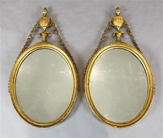 A pair of George III giltwood and gesso oval wall mirrors, W.1ft 5in. H.2ft 7.5in.